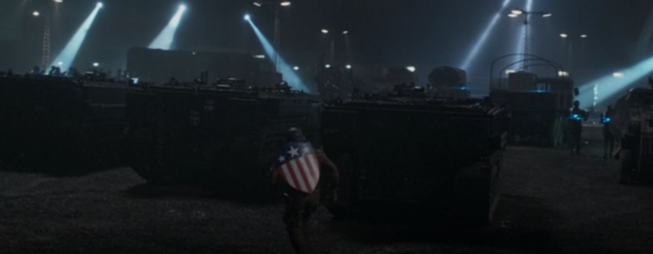 Steve with his bright stars and stripes shield at his back, by night on an infiltration mission.