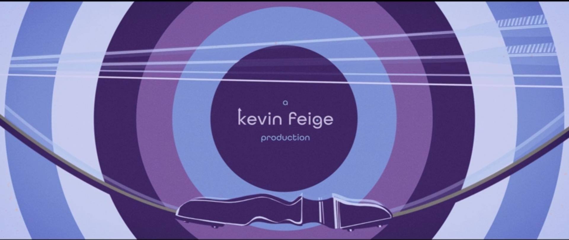 A still of the credits, saying "a Kevin Feige Production". His name is at a center of concentric circles like a target, the colors are purple, light blue, pink, more purple, and white. At the bottom of the pic is a drawn bow, in pink-ish purple.
